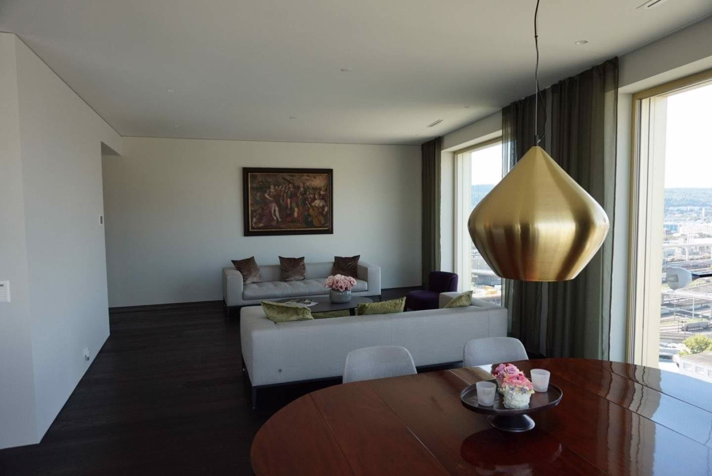 Wohnzimmer mit neutralem Farbkonzept und eleganter Beleuchtung