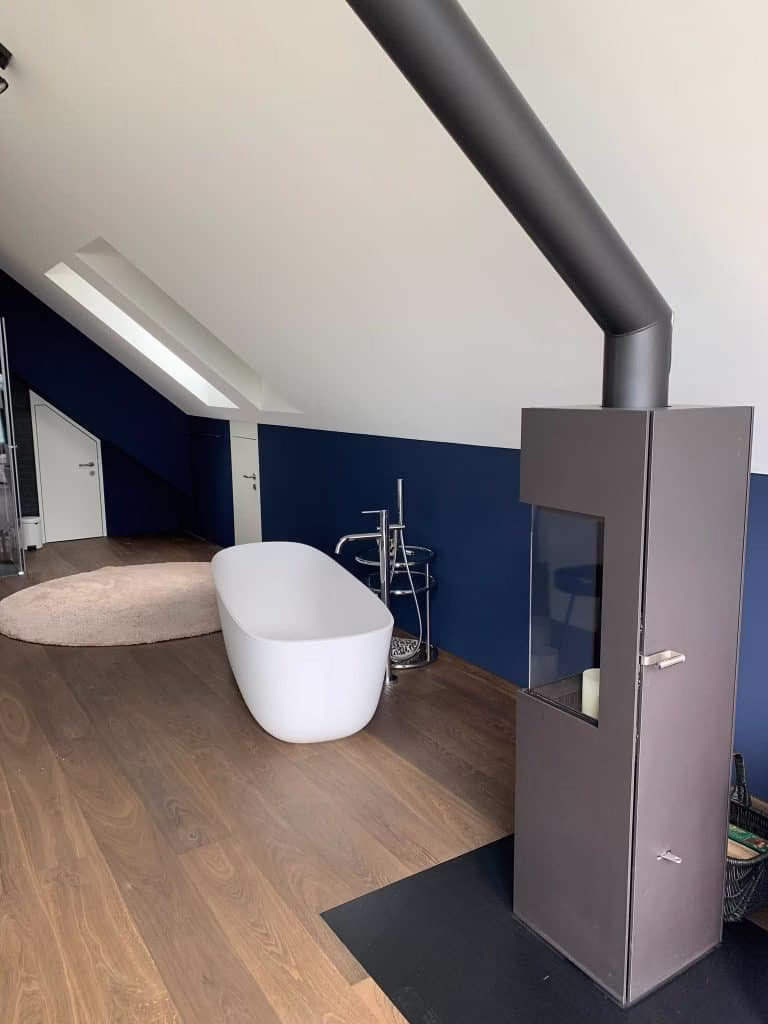 Malerarbeiten Zürich – blaue Akzentwand im Bad mit freistehender Wanne
